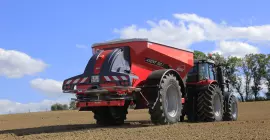 Разбрасыватель удобрений AXENT в работе в поле