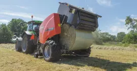KUHN FB 3135 AUTOMATE выталкивает круглый тюк, обмотанный пленкой.