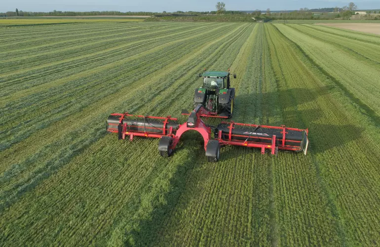 Ленточный валкообразователь MERGE MAXX 1090 в работе на поле люцерны