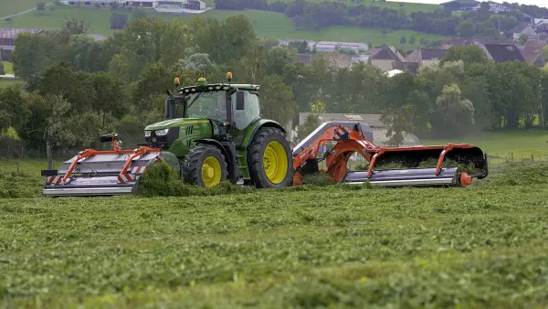 Фронтальный ленточный валкообразователь MERGE MAXX 440F в сочетании с валкообразователем MERGE MAXX 950 на работе в поле.